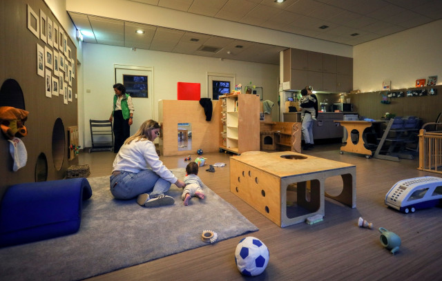 In de kinderopvang met twee baby's en drie begeleiders.