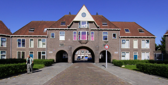 Gebouw met een puntdak en een onderdoorgang in De Hoogte