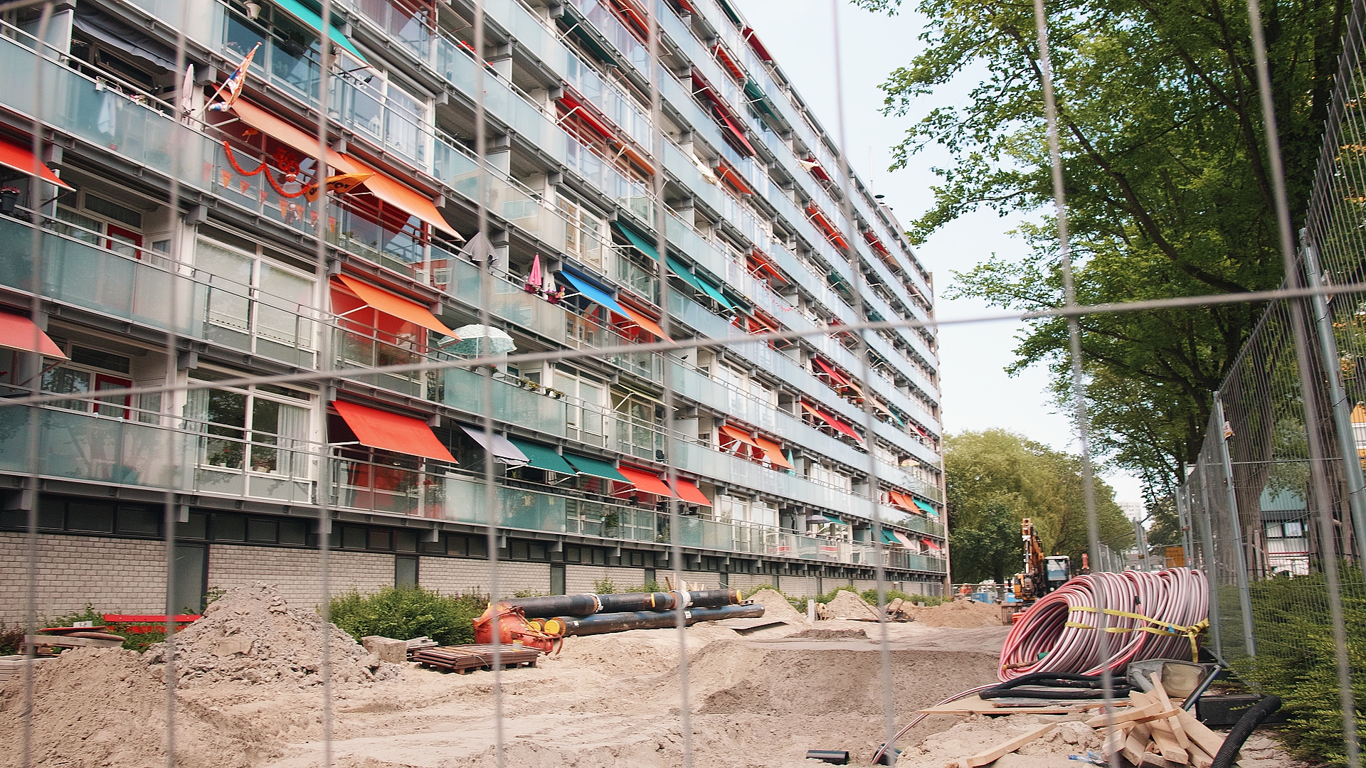 Still uit de aflevering De energietransitie, waarop een opengebroken straat te zien is voor een flat
